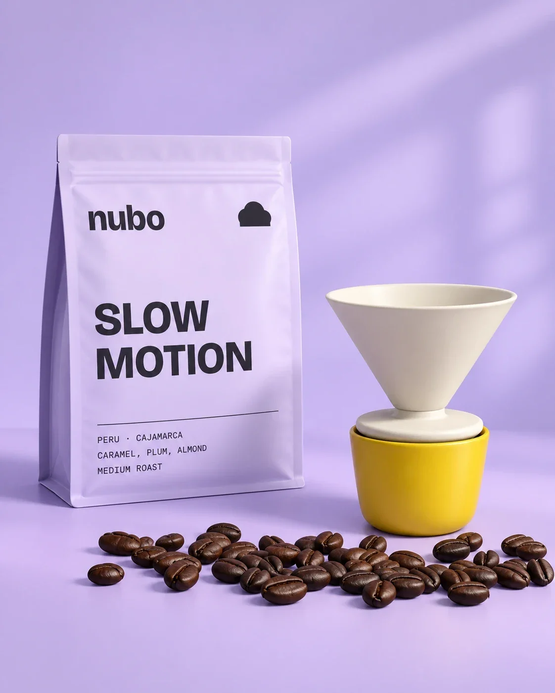 A Slow Motion pouch beside a white dripper on a yellow cup, with roasted beans on lilac