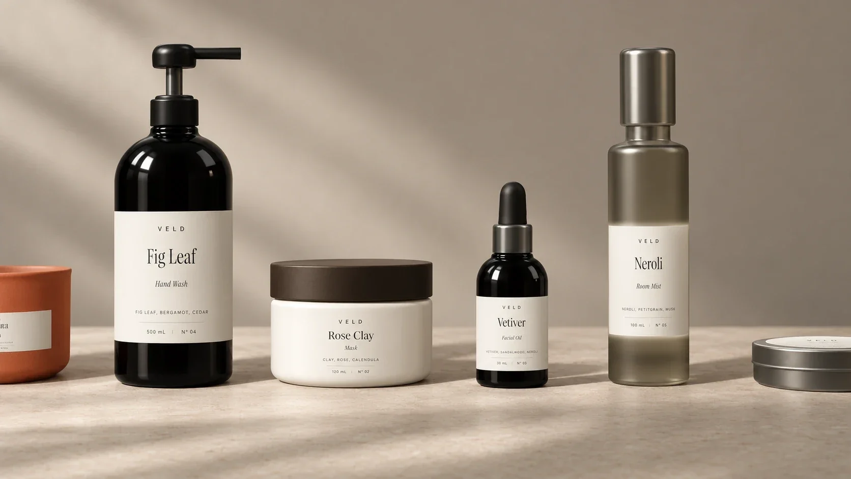 The Veld range on a stone counter in raking light: Fig Leaf, Rose Clay, Vetiver, and Neroli